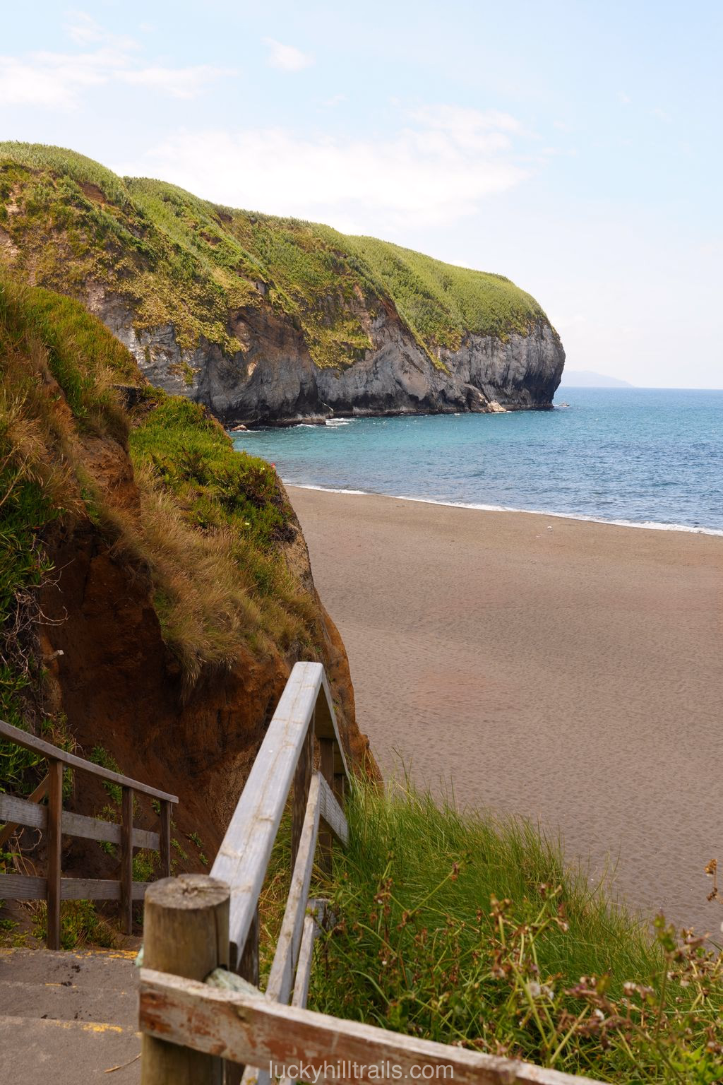 Areal de Santa Barbara beach with wooden stairs and a rocky headland, São Miguel island, Azores