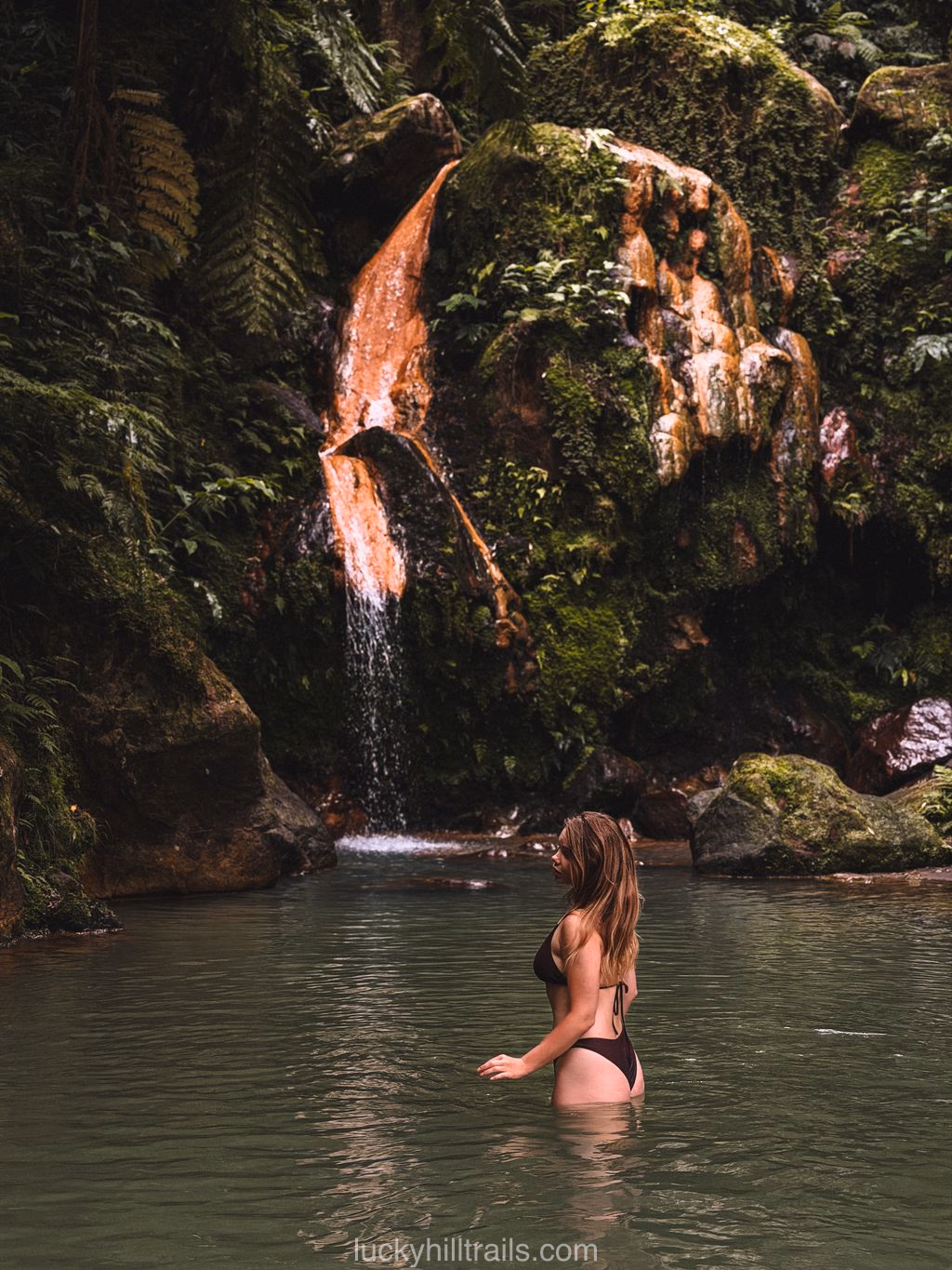 Iron-stained waterfall flowing into the thermal pool at Caldeira Velha, São Miguel, Azores