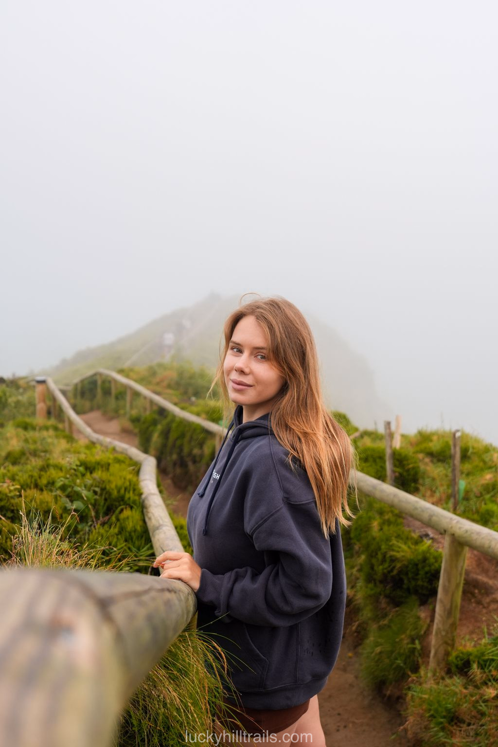 Narrow Grota do Inferno viewpoint with a wooden fence in the fog, São Miguel, Azores