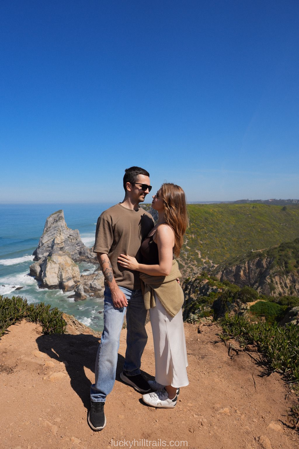 A couple at the viewpoint of Cabo da Roca with cliffs and the Atlantic Ocean in the background, Portugal