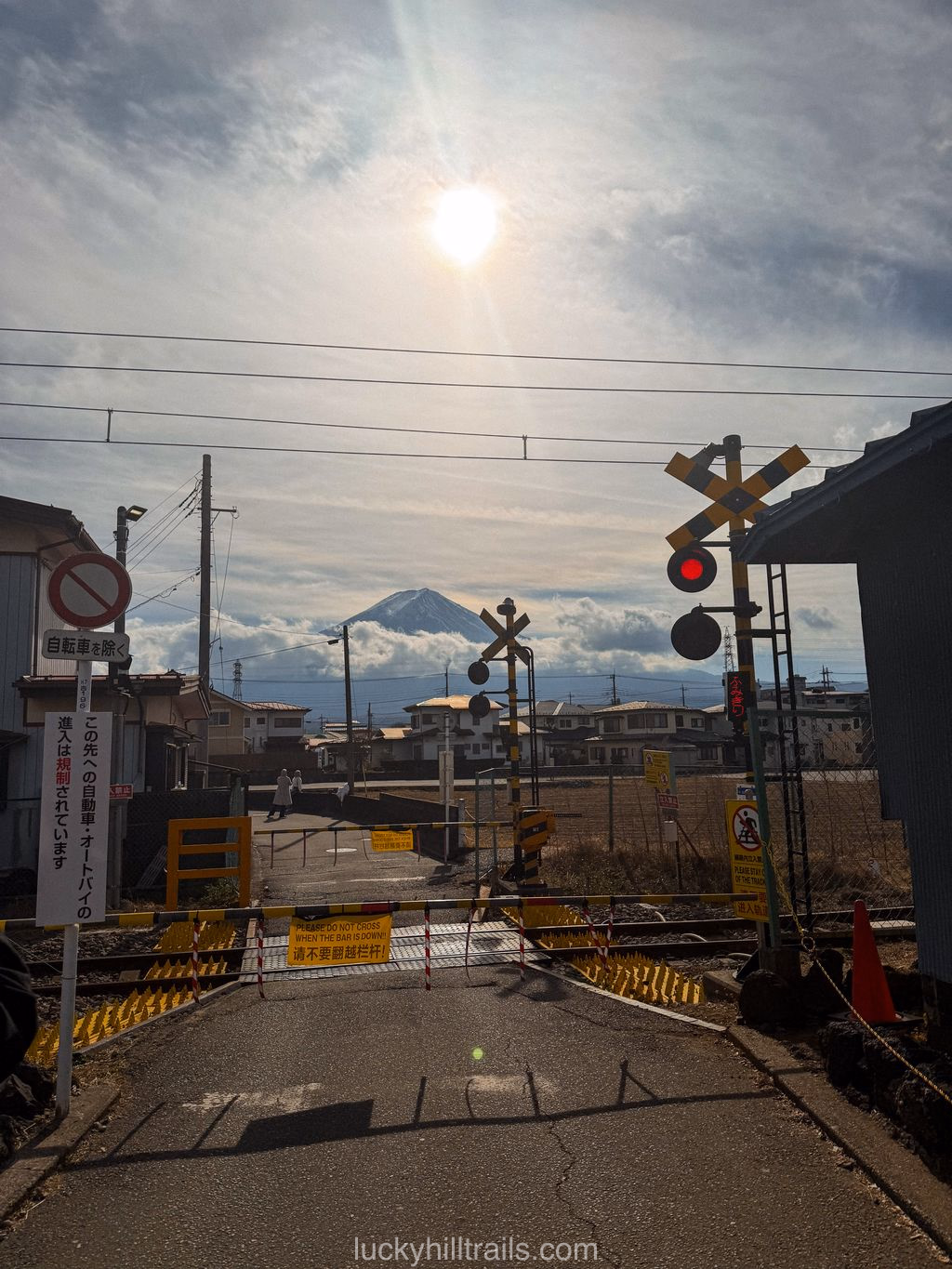 Japanese railway crossing with a train against Mount Fuji