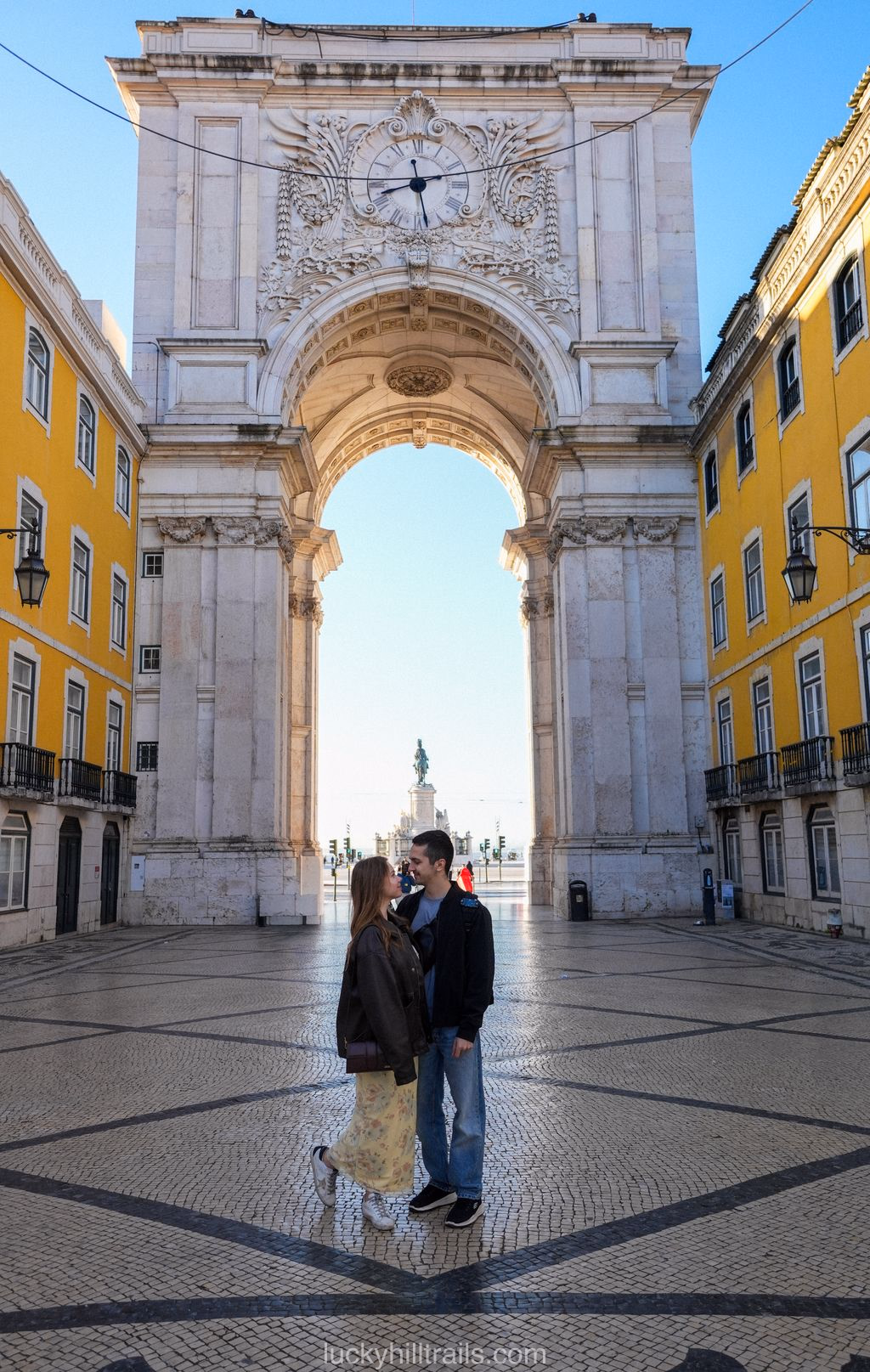 Couple kissing under the triumphal Arco da Rua Augusta at Praça do Comércio, Lisbon, Portugal