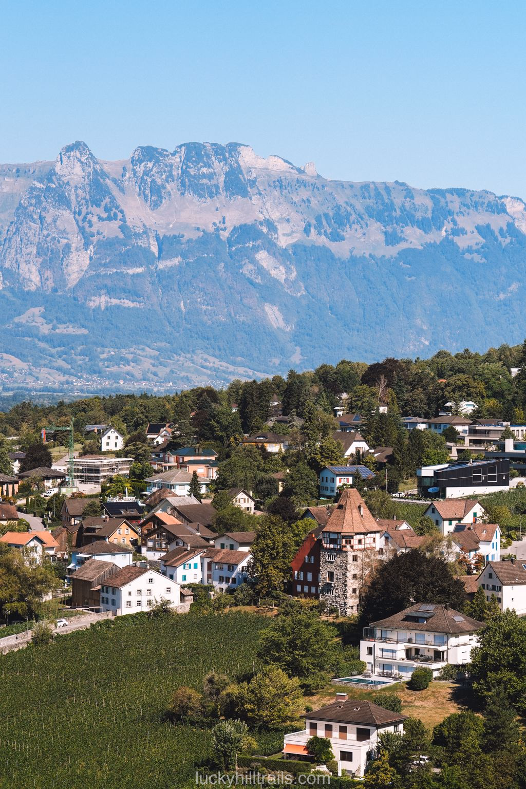 View of Vaduz with a red tower among vineyards and mountains