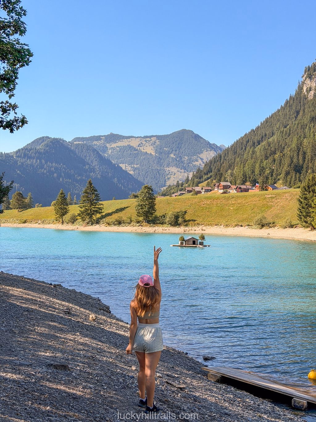 Woman waving on the shore of Lake Gänglesee